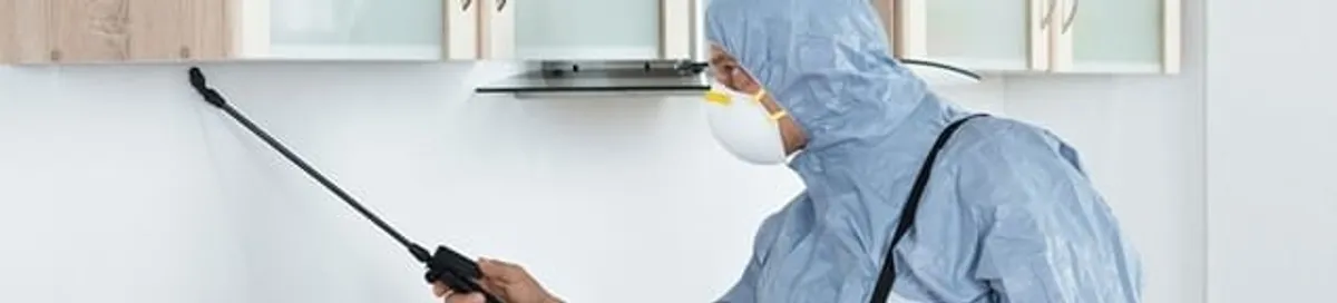 Termite treatment technician applying indoor pest control spray in Seattle, WA